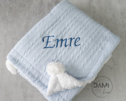Personalised knitted baby blanket with white sherpa lining and 2 pom-poms.