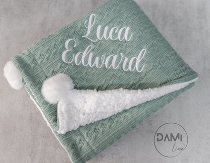 Personalised knitted baby blanket with white sherpa lining and 2 pom-poms.