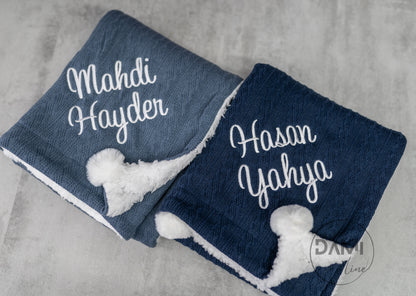 Personalised knitted baby blanket with white sherpa lining and 2 pom-poms.