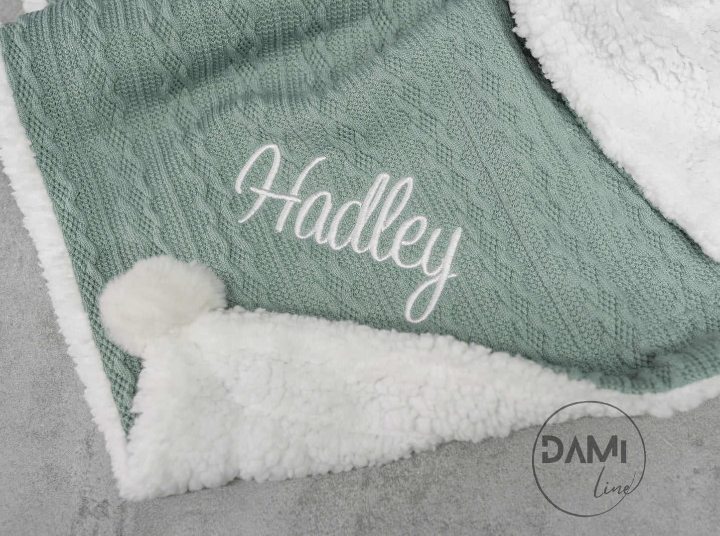 Personalised knitted baby blanket with sherpa lining and 2 pom-poms.