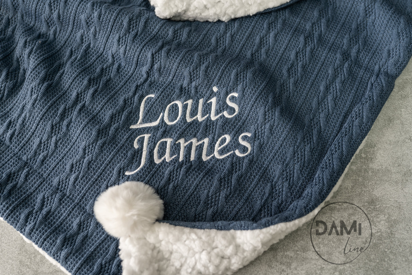 Personalised knitted baby blanket with sherpa lining and 2 pom-poms.