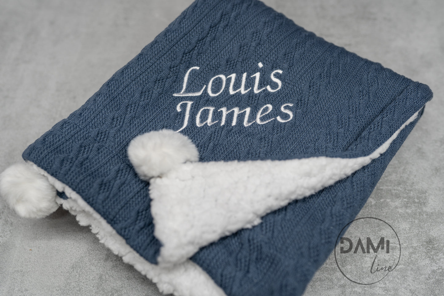 Personalised knitted baby blanket with sherpa lining and 2 pom-poms.