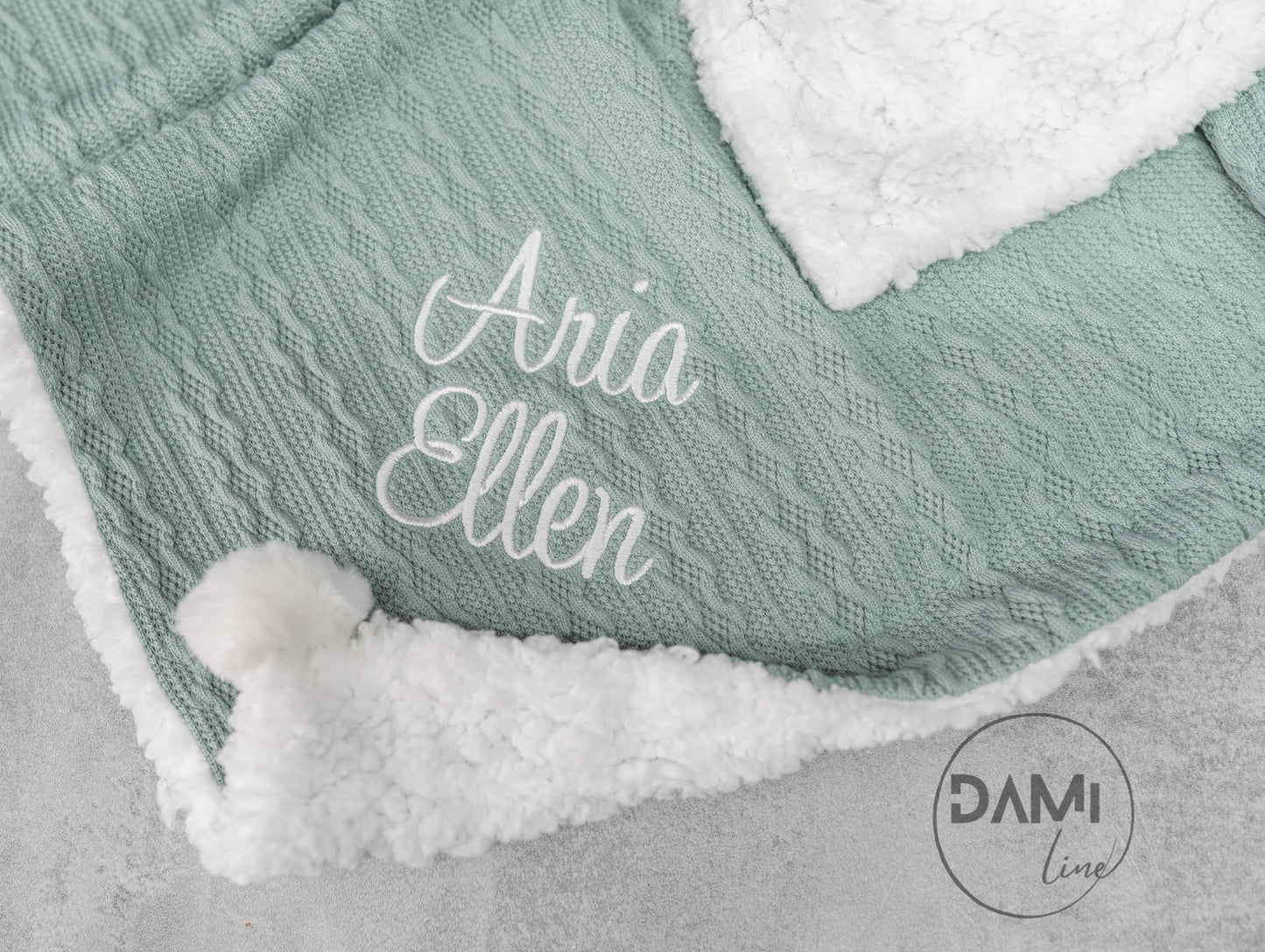 Personalised knitted baby blanket with sherpa lining and 2 pom-poms.