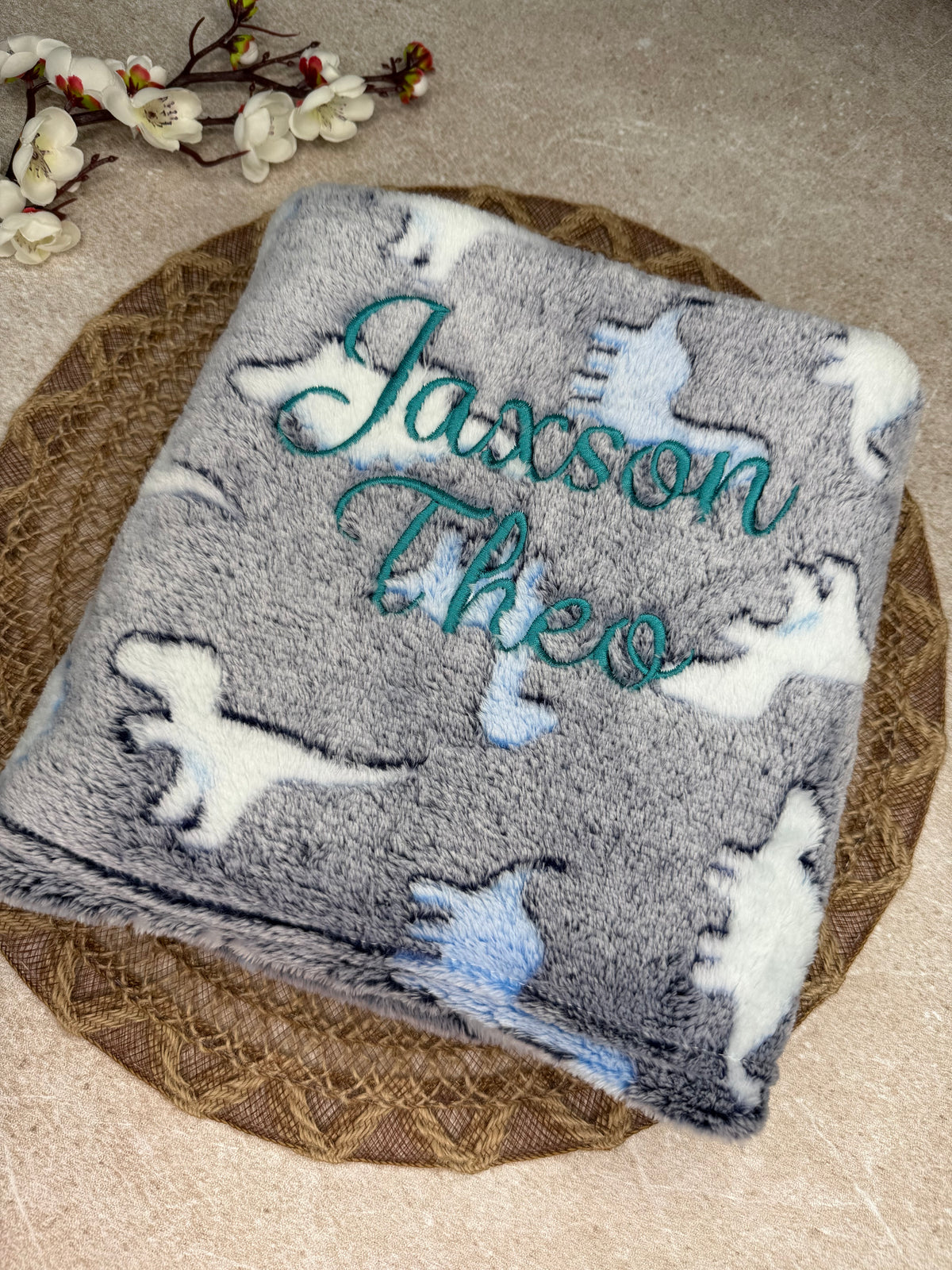 Blue fleece blanket with dinosaur print. Personalised