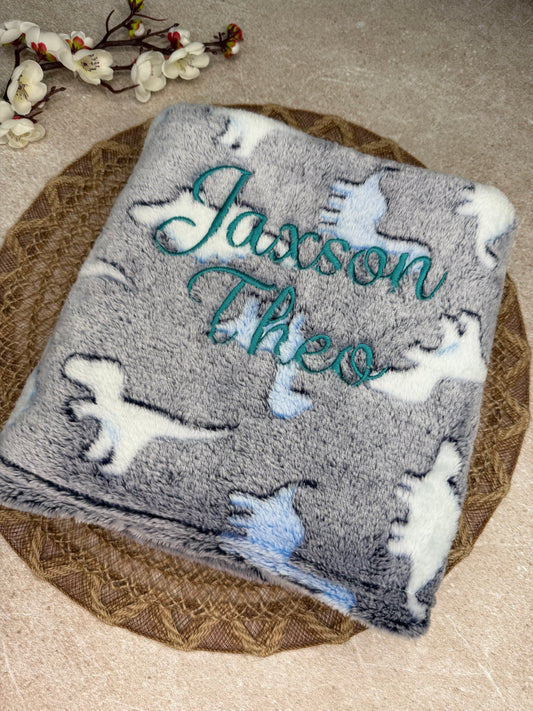 Blue fleece blanket with dinosaur print. Personalised