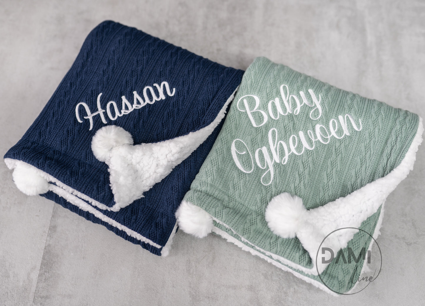 Personalised knitted baby blanket with white sherpa lining and 2 pom-poms.