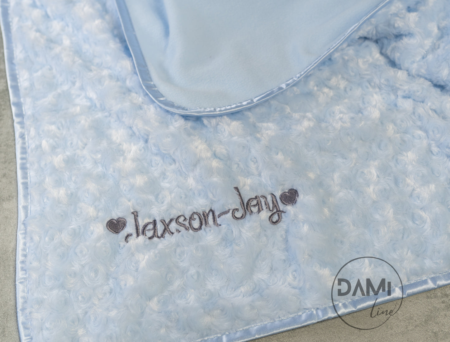 Personalised embroidered baby rosebud blanket with fleece back and satin trim.